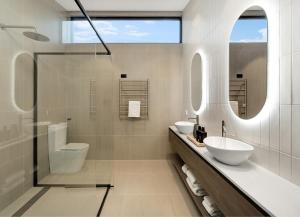 a white bathroom with two sinks and a shower at The Lane Retreat in Pokolbin