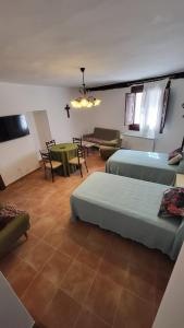 Habitación con 2 camas, mesa y sofá en La Casona de Roser, en Cardenete