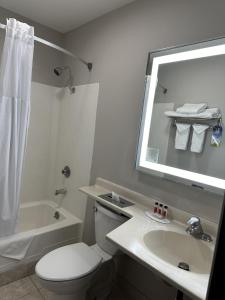 y baño con aseo, lavabo y espejo. en Days Inn by Wyndham Medford, en Medford