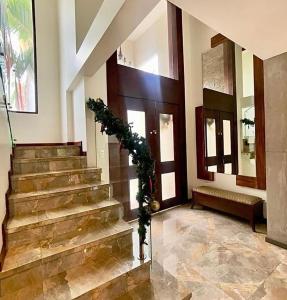 un vestíbulo con una escalera con una guirnalda en Casa en alquiler en Entre Lagos, en Guayaquil
