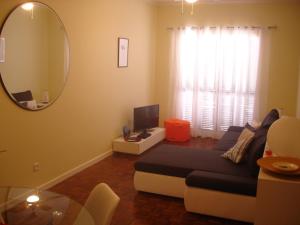 uma sala de estar com um sofá e um espelho em Shearwaternest Apartment AL em Funchal