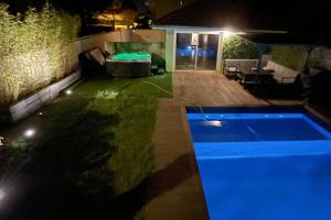 einen Hinterhof mit Pool in der Nacht in der Unterkunft Unique! jacuzzi privé 35°C + cinéma Villa entière in Meyzieu