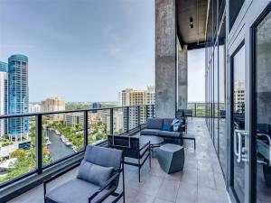 a balcony with chairs and tables on a building at Sleek & Stylish Jr. 1-BR Retreat - Las Olas in Fort Lauderdale