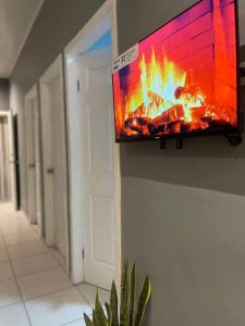 a television hanging on a wall with a fire on it at Casa Residencial Quinta in Comayagua
