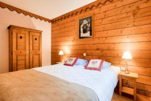 a bedroom with a bed and a wooden wall at Résidence L'Ecrin des Neiges - maeva Home - Appartement 2 pièces 4 personnes - Sélection MAE-7984 in Tignes