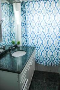 een badkamer met een wastafel en blauw en wit behang bij Hostal EntreOrientes in Viña del Mar