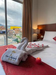 Una toalla con un cisne en una cama con velas en HOTEL LA PALMERA DE ORO, en Tarapoto