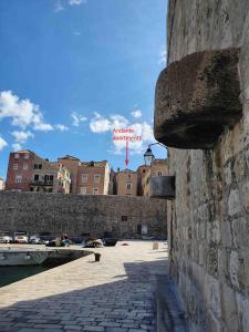 a stone wall with a sign on top of it at Pocco Andante in Dubrovnik +4 photos