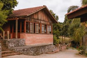 uma pequena casa de tijolos com uma parede de pedra em Afeto Pousada em Bento Gonçalves