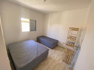 Cette petite chambre comprend un lit et une échelle. dans l'établissement AmaralHouse, à Itanhaém 3 autres photos