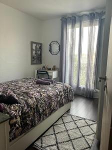1 dormitorio con cama y ventana en La veranda du parc, en Issy-les-Moulineaux