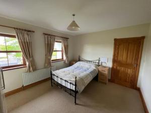 a bedroom with a bed and a wooden door at Country Hideaway in Limerick