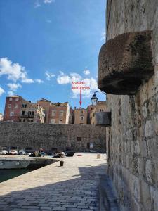 un muro di pietra con un cartello sopra di Andante con nobile - brand new a Dubrovnik