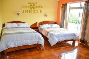 a bedroom with two beds and a sign that reads therapy at HOTEL JHERLY in Nuevo Tingo