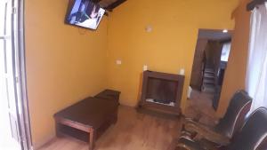 a living room with a tv and a table and chairs at La Posada Campestre Cabañas in El Cocuy