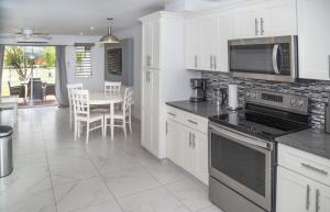 a kitchen with white appliances and a table with chairs at 101G Jolly Harbour, Garden View in Jolly Harbour
