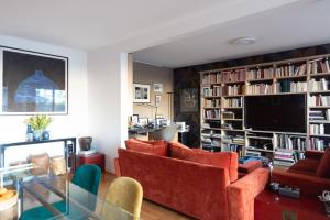 a living room with orange chairs and a television at Spacious apartment near Champ-de-Mars in Paris