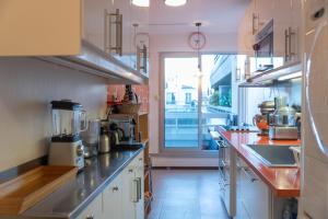 a large kitchen with white cabinets and a large window at Spacious apartment near Champ-de-Mars in Paris