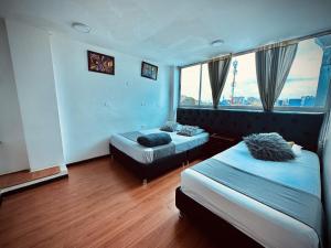 una camera d'albergo con due letti e una finestra di Bogotá Elite a Bogotá