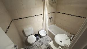 a bathroom with a toilet and a sink and a tub at Apartamento Flowers in Buenos Aires +22 photos