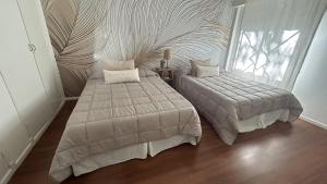 Un dormitorio con dos camas y una gran ventana. en Apartamento Flowers, en Buenos Aires
