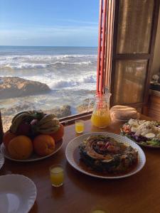 a table with plates of food and a view of the ocean at Amaan ⴰⵎⴰⴰⵏ Cottage in Agadir