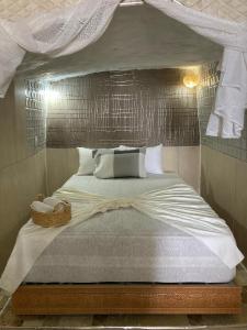 a bedroom with a large bed with a canopy at Amaan ⴰⵎⴰⴰⵏ Cottage in Agadir