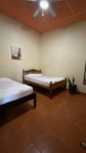 um quarto com 2 camas e uma ventoinha de tecto em Hostal Casa Bonita Ometepe em Rivas