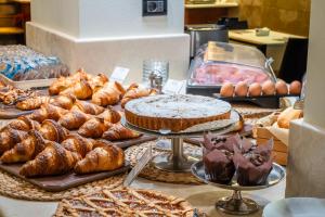 einen Tisch mit verschiedenen Backwaren, Brot und Kuchen in der Unterkunft Hotel Airone in Grosseto