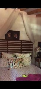um quarto com uma cama com uma cabeceira de madeira em LE BOUTIQUE SUÍTES - PRAIA de MARESIAS em Maresias