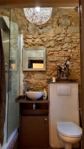 a stone bathroom with a toilet and a sink at Murisengo Country Houses in Murisengo