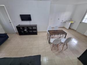 a living room with a table and chairs and a television at Depa muy ubicado Cortes 15B in Querétaro