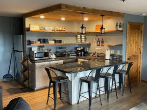 uma cozinha com uma ilha com bancos de bar em Siskiyou Mountain Place, Ashland em Buckhorn Springs