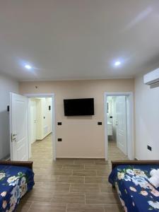 een slaapkamer met 2 bedden en een flatscreen-tv bij Hodo guest house in Përmet