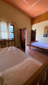 1 dormitorio grande con 2 camas y ventana en Hostal Casa Bonita Ometepe, en Rivas