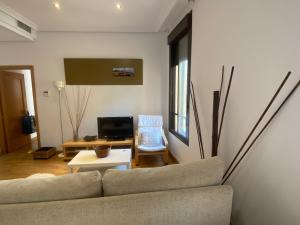 sala de estar con sofá y mesa en Apartamentos Caceres, en Cáceres