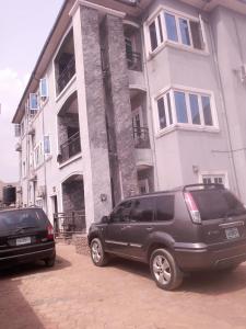 deux voitures garées devant un bâtiment dans l'établissement Chima's Place, à Ihiala