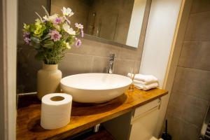 ein Badezimmer mit einem Waschbecken und einer Vase mit Blumen in der Unterkunft GOLDEN HAVEN in Reading