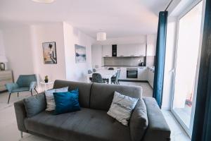 ein Wohnzimmer mit einem Sofa und einer Küche in der Unterkunft Bright 2 Bedroom flat in Sliema! in Sliema