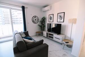 Una sala de estar con un sofá y un televisor. en Bright 2 Bedroom flat in Sliema!, en Sliema
