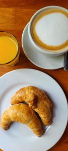 een bord met twee croissants en een kopje koffie bij CASI EN CASA in Lincoln