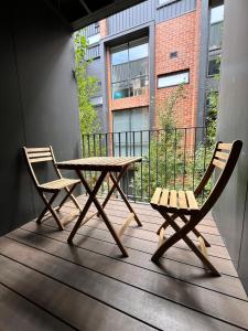 a wooden table and two chairs on a balcony at Inn Central Townhouse at Canberra in Canberra