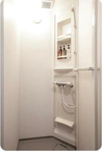 ein Bad mit einer Dusche und einem weißen Kühlschrank in der Unterkunft Arakawa-ku - House / Vacation STAY 66906 in Tokio
