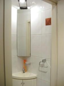 ein weißes Badezimmer mit einem Waschbecken und einem Spiegel in der Unterkunft KNOKKE ZOUTE near beach appartment with garage in Knokke-Heist
