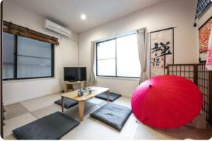 ein Wohnzimmer mit einem roten Regenschirm und einem Tisch in der Unterkunft Arakawa-ku - House / Vacation STAY 66906 in Tokio