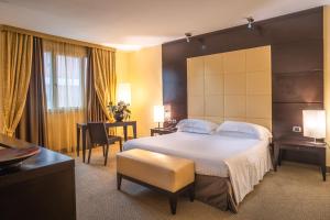 um quarto de hotel com uma cama grande e uma secretária em Hotel Airone - Ombrellone incluso al bagno Dolce Vita a Marina dal 15 giugno al 15 settembre em Grosseto