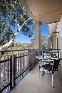 een patio met een tafel en stoelen op een balkon bij Quest Alice Springs in Alice Springs