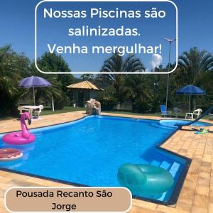 a swimming pool in a resort with a sign that reads nosas pisas at POUSADA RECANTO SÃO JORGE in Águas de Lindoia