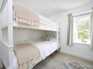 ein weißes Schlafzimmer mit einem Etagenbett und einem Fenster in der Unterkunft 4 Bed in Braithwaite SZ533 in Braithwaite