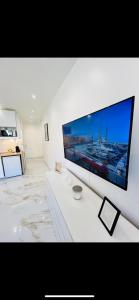 TV de pantalla plana grande en una pared blanca en Studio Promenade des Anglais en Niza